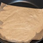 Flattened dough between parchment paper